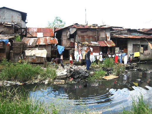 man swimming by slum.jpg